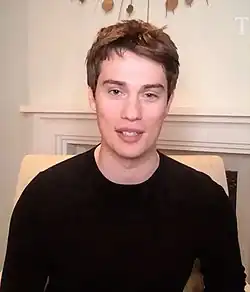 A man with light brown hair looking forward, smiling slightly