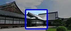 Wooden building with a hip-and-gable roof, white walls and wooden sliding doors.