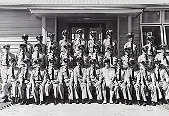 Group portrait of uniformed staff in front of building