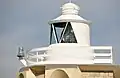 Close-up, showing the lantern and lens (centre) and emergency battery light mounted on the gallery (left).