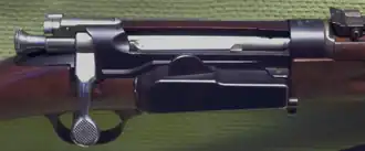 Close-up view of the metal action on a Norwegian M1912 Krag–Jørgensen carbine, showing the hinged side magazine door.