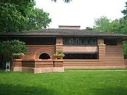 Photograph of a modern-looking house, green trees in background