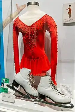 Museum display of Fratianne's dress, which is red and covered with spangles on the front and top