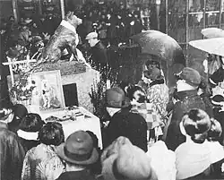 Crowd of people paying respects to dog statue