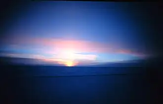 Additional to foreglow here refracted sunlight reaches the South Pole just before actual sunrise. At Earth's poles the Sun appears at the horizon only and all day around equinox, marking the change between the half year long polar night and polar day.