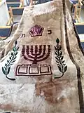 Parochet with the emblem of the State of Israel, Menorah, and olive tree branches with leaves.