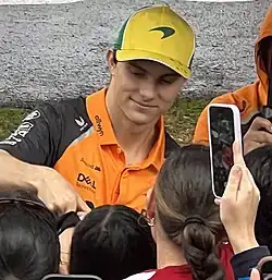 Piastri signing autographs behind a crowd of fans at the 2025 Australian Grand Prix