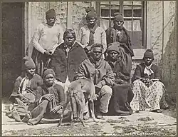 Group photograph of nine Aboriginal men and women seated and standing outside a building.