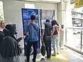 Passengers using ticket vending machines