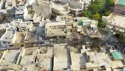 Burned aircraft wreckage distributed across a row of buildings.