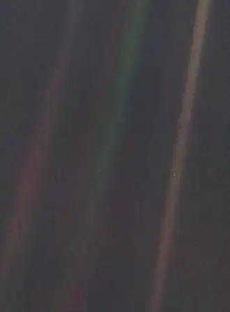Image 12 Pale Blue Dot Photo credit: NASA/JPL Pale Blue Dot is the name given to this 1990 photo of Earth taken from Voyager 1 when its vantage point reached the edge of the Solar System, a distance of roughly 3.7 billion miles (6 billion kilometres). Earth can be seen as a blueish-white speck approximately halfway down the brown band to the right. The light band over Earth is an artifact of sunlight scattering in the camera's lens, resulting from the small angle between Earth and the Sun. Carl Sagan came up with the idea of turning the spacecraft around to take a composite image of the Solar System. Six years later, he reflected, "All of human history has happened on that tiny pixel, which is our only home." More selected pictures