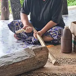 Peeling the bark from a u'a trunk