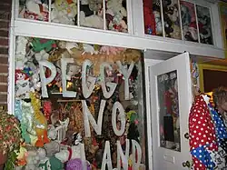 A storefront with "PEGGY NOLAND" visible in the window display, which is filled with stuffed animals