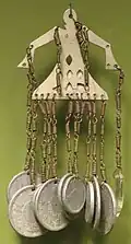 A pendant made of Japanese coins, brass, aluminum and glass