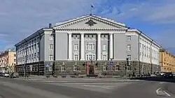 A grey building with white columns