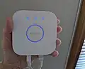 The Philips Hue Bridge (second generation) can hang on the wall or lie on a table. It plugs in to electricity, and its Ethernet cable goes to a wireless router (or by means of a hub, to the wired Ethernet).
