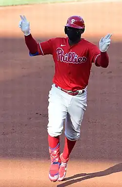 Didi Gregorius in 2020, rounding the bases with his hands up, wearing a dark-colored face mask