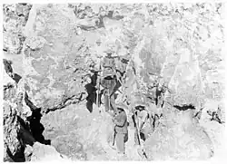 Chinese phosphate workers on Nauru standing between limestone pinnacle