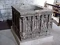 The baptismal font, behind which are steps down to the crypt