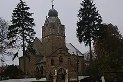 A image of a church in Ukraine surrounded by coniferous trees