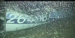 A crumpled section of the Piper's rear fuselage with the characters 264DB barely recognizable