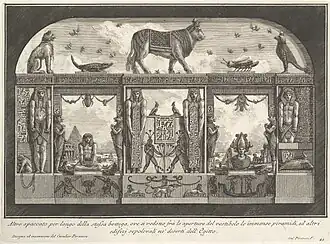 Engraving of imagined Egyptian temple wall with hieroglyphs, statues, animal figures, and scenes of pyramids and ruins in background