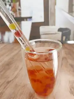 Popping boba in bubble tea, being drunk through a straw.