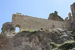 A ruined stone wall on a rocky hill