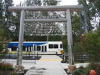 Timber gateway and a waiting train. Facsimiles of historical newspaper headlines are at the base of the wooden poles.