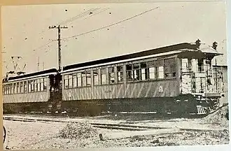 Two electric railway cars, one with a pantograph, at the end of a track