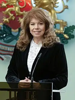 Official presidential portrait of Iotova smiling and wearing a white shirt and a blue suit jacket.