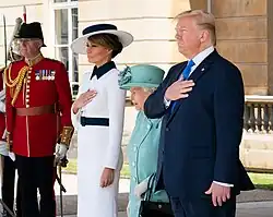President Trump and First Lady Melania Trump with Queen Elizabeth II at the West Terrace of Buckingham Palace, listening to the U.S. national anthem being played by the band of the Grenadier Guards.