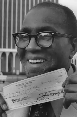 King in 1977, holding the check he received from the Muscogee County Democratic Executive Committee for $324.70