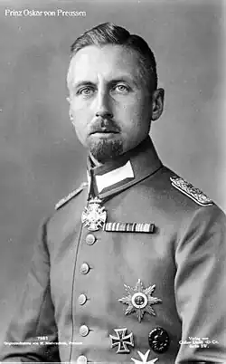 Oskar is pale-eyed, has a short goatee and wears uniform and medals