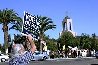 Protesters holding signs opposing Prop 8. A sign reads "Vote No on Prop 8" and "Equality for All"
