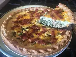 Quiche au fromage de Gruyère with a slice removed for display