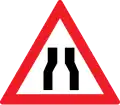 Road narrows on both sides