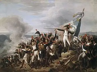 Painting shows a man in a blue uniform with white breeches standing on a mountaintop amid a crowd of soldiers. He gestures dramatically with his sword as he holds a French tricolor. Some of the soldiers are firing downhill.
