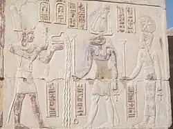 Relief at Deir el-Haggar depicting Titus (left) making an offering before Khnum (middle) and Satis (right).