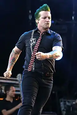 Tré Cool pictured during a performance, glancing to his left