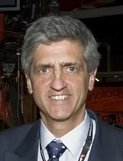 A middle-aged man wearing a jacket and tie