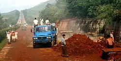 Roadwork construction in North Korea. The blue truck in the foreground is a Chinese-made Dongfeng EQ140.