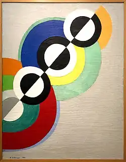 Abstract painting of concentric circles arranged along a diagonal axis. The axis bisects each circle, and each half is a different color.