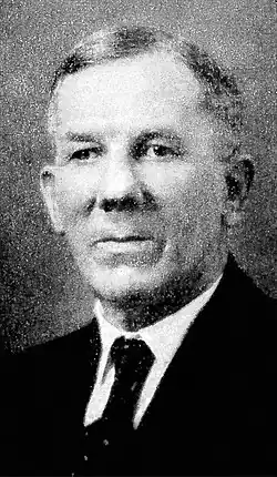 Black and white portrait of a man wearing a suit and tie