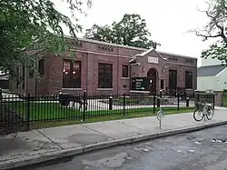 Roosevelt Library, a small Tudor Revival building surrounded by a neat lawn and black fence