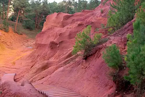 Red ochre cliffs near Roussillon in France. Red ochre is composed of clay tinted with hematite. Ochre was the first pigment used by humans in prehistoric cave paintings.