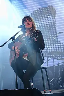 Closeup image of Rozalén sitting down and performing