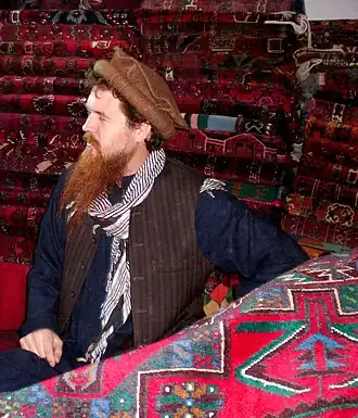 Image 54Shoppers examining traditional Afghan rugs in a market in Nangarhar Province, Afghanistan. (from Culture of Afghanistan)