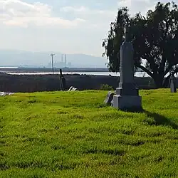 A obelisk in the rural Collinsville cemetery with the Gateway Generating Station visible in the background