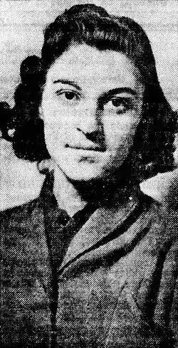 A young white woman with dark curly hair, smiling from an ambulance window